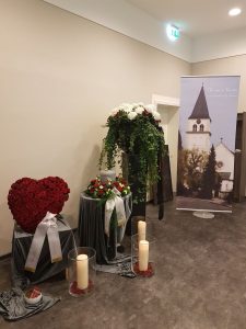Urne mit Blumenschmuck, Herz aus Rosen und Kerzen